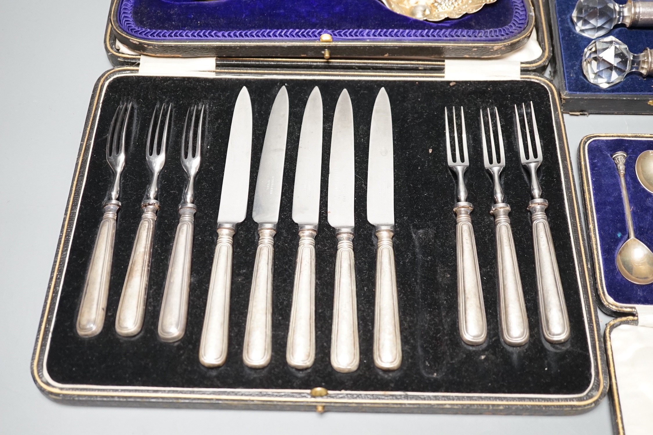 Two 18th century silver 'berry' spoons in associated case and three other cased sets including, pair of silver mounted glass knife rests, a cased set of six seal top coffee spoons and a part set of dessert eaters.